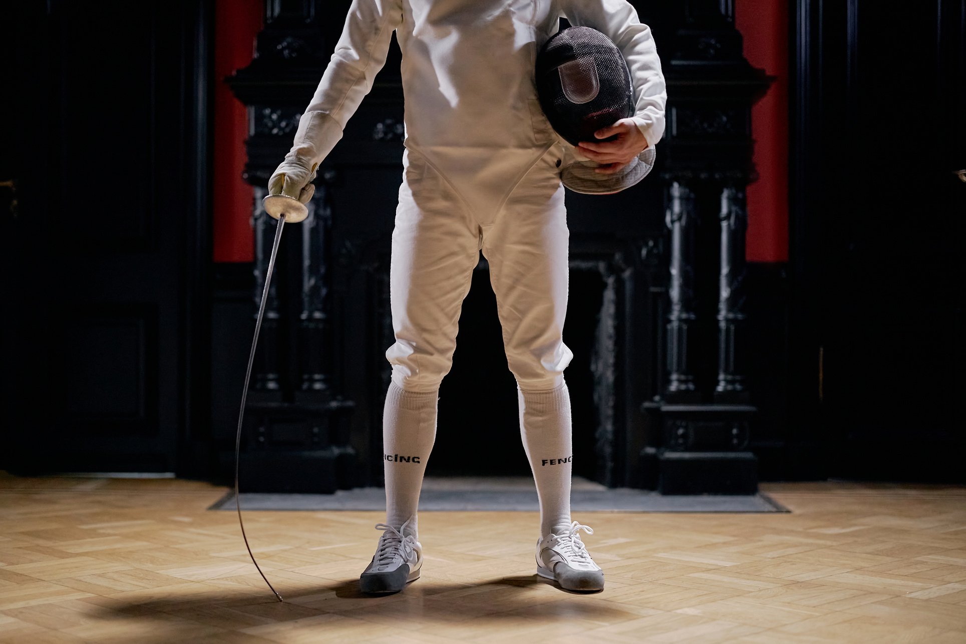 Man Holding Fencing Sword and Helmet